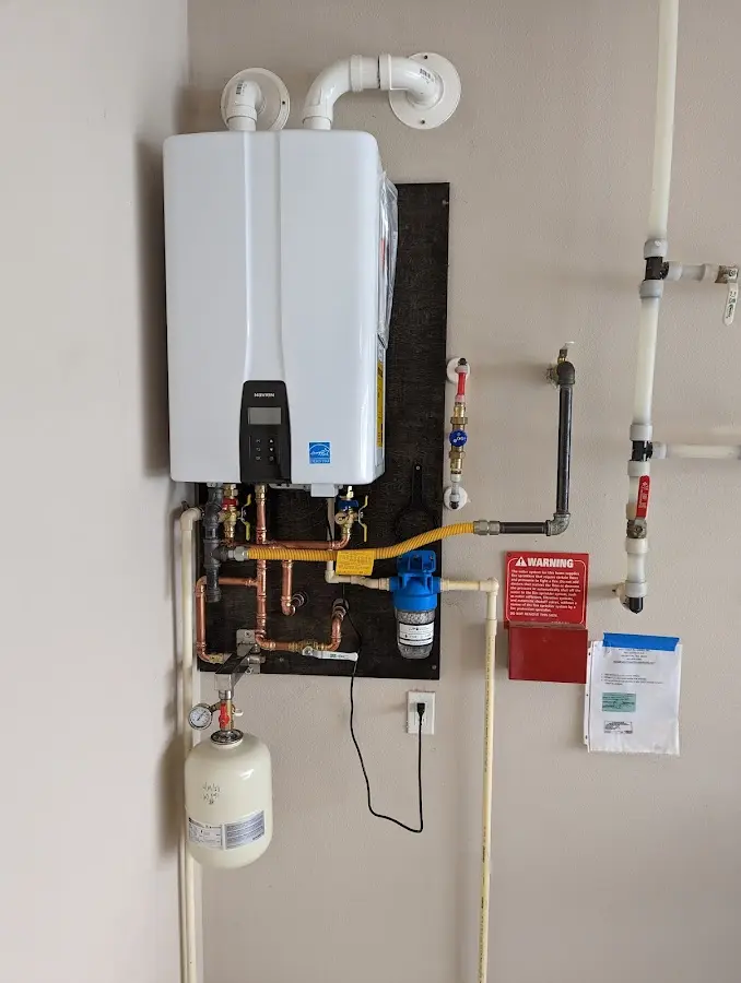 Professional plumber installing copper piping in a Oakfield home